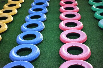 Colorful Painted Tires Arranged in Rows on Artificial Grass Playground