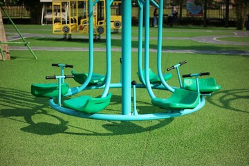 Playground Equipment Featuring Colorful Carousel Under Sunny Sky