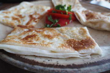 Tasty turkish Gozleme served with fresh tomato and herbs