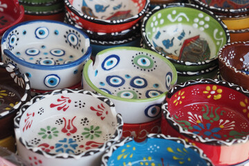 Colorful hand-painted ceramic bowls displayed at a market