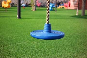 Blue Rope Swing Seat Hanging in a Vibrant Playground