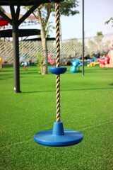 Blue Rope Swing Seat Hanging in a Vibrant Playground