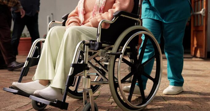 Legs, wheelchair and nurse in garden with patient at retirement village, push and support for mobility. People, caregiver and job with elderly person with disability, feet and help for rehabilitation