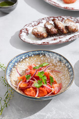 Tomato and red onion salad, bright daylight, overhead composition