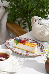 Cheesecake slice with assorted berries, bright natural light, overhead composition