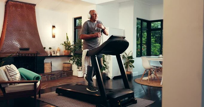 Senior man, music and exercise on treadmill for fitness, power walking or drinking water for health. Headphones, cardio machine and happy person in home for workout, audio or training in retirement