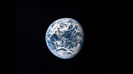 The Earth, a blue and green planet with a dark blue ocean and white clouds, viewed from space against a black background.