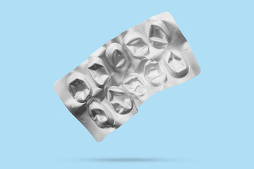 Empty medicine aluminium foil silver blister packaging isolated on blue background