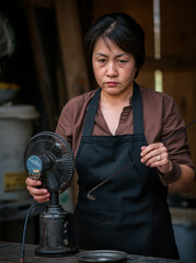 A focused artisan preparing tools for a creative project in a rustic workshop.
