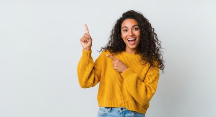 Excited young woman points up and forward with a joyful expression