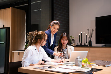 Focused female intern listening to senior  business woman mentor teacher explaining online strategy looking at laptop computer teach trainee training new worker learning new skill at workplace.