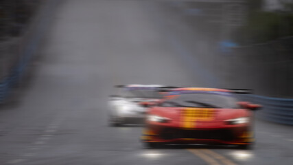 Obraz premium Motion blur race car racing on speed track, Motion blurred super car race on street track circuit, Automobile automotive transportation vehicle background.