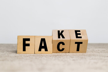 flip wooden blocks with fake and fact words symbol on white background