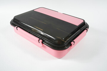 Plastic and stainless lunch box, which is black and pink in color. n white background, food...