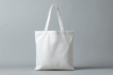 Blank, white tote bag on gray backdrop