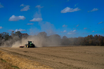 Tractor ploughing the field. Autumn farming in the countryside. Tractor on rural farmland....