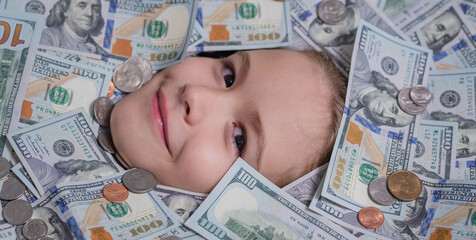 Funny kids face in money dollars banknotes background. Money banknotes, cash dollars bills, 100 American dollars banknotes.