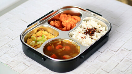 Bring packed lunch. Rice topped with nori, Japanese curry, karage and fried scrambled eggs.      