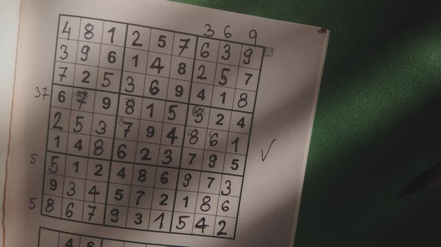 Solved Suduku numbers puzzle revealed in dimly lit study TOP DOWN shot