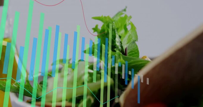 Wooden spoon entering, lifting and tossing salad greens and showing bar graphs mapping nutrients