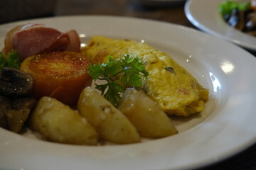 Classic Breakfast Plate with Omelette, Bacon, Tomato, and Potatoes