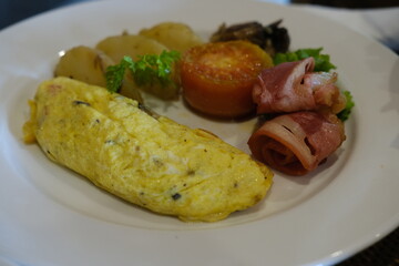Classic Breakfast Plate with Omelette, Bacon, Tomato, and Potatoes