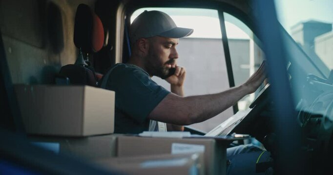 Professional Delivery Truck Driver in Car Talking by Phone with Customer, Filling Out Papers, Using Digital Tablet. Courier Working in Express Delivery Service of Online Orders, E-Commerce Goods, Food