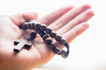Obraz premium Hand holding rosary beads