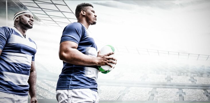 Determined young african american rugby player holding ball in stadium, copy space - Powered by Adobe
