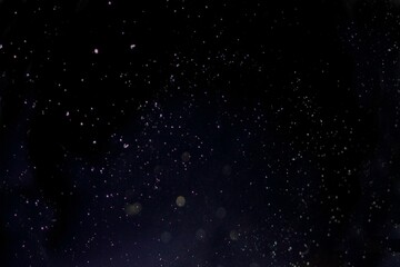 Dark speckled expanse is being shown in flat vector, featuring floating light specks and bokeh orbs