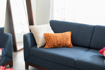 a couch sitting inside of a living room next to a mirror