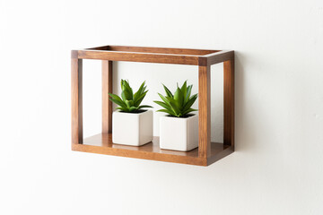 Rectangular open wooden wall shelf in medium walnut finish featuring two minimalist ceramic square...