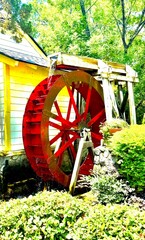 Charming water wheel on the side of an old farmhouse — nostalgic and timeless, evoking the simplicity and ingenuity of rural life © Curiosity Photos