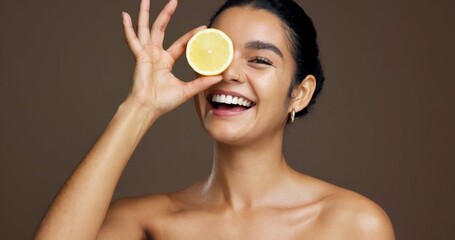 Happy woman, portrait or lemon with vitamin C in studio for skincare detox on a brown background....