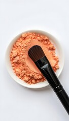 makeup brush with bronzer on a small plate
