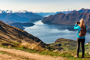 Rear view of hiking tourist  making a heart symbol at the top of Roys Peak Wanaka New Zealand