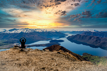 Rear view of hiking tourist  making a heart symbol at the top of Roys Peak Wanaka New Zealand