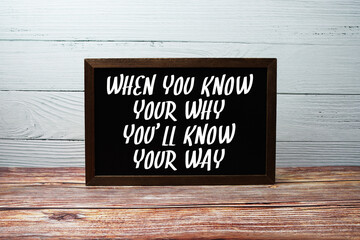 When You Know Your Why You'll Know Your Way text with blackboard on wooden background