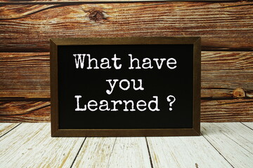 What have you Learned? text with blackboard on wooden background