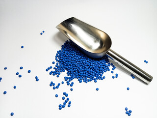 Blue plastic masterbatch, polymer carries colorful pigments with small scoops poured into a white background, suitable for product catalog design of industrial plastic manufacturing company profiles