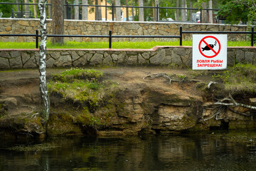 Fishing is prohibited. The sign on the lake in the park. The inscription is in Russian