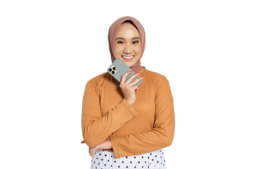 Cheerful Muslim woman in hijab smiling while holding smartphone to cheek isolated on transparent background