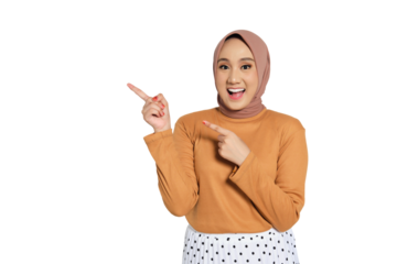 Excited Muslim woman in hijab smiling widely and pointing up with enthusiastic expression isolated on transparent background