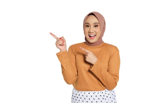 Excited Muslim woman in hijab smiling widely and pointing up with enthusiastic expression isolated on transparent background