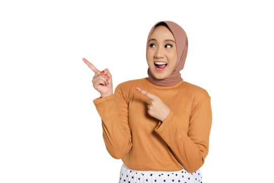 Excited Muslim woman in hijab smiling widely and pointing up with enthusiastic expression isolated on transparent background