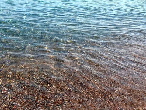 Sea clear gentle waves at the pebble beach 
