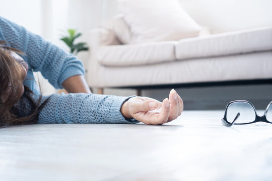 Woman fainting and collapsing on the floor, possibly caused by low blood pressure, heart problems, heat exhaustion, low blood sugar (hypoglycemia) or emotional stress