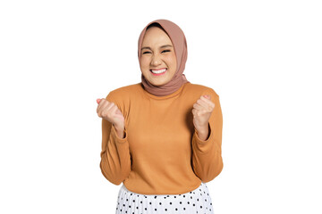 Cheerful woman wearing hijab celebrating success with raised fists isolated on transparent...