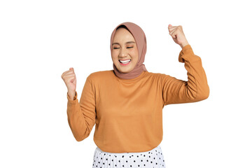 Cheerful woman wearing hijab celebrating success with raised fists isolated on transparent...