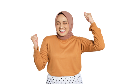 Cheerful woman wearing hijab celebrating success with raised fists isolated on transparent background